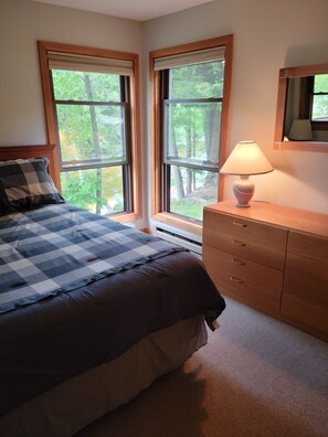 A bedroom with a bed, a dresser, and two windows with a view of trees. - Riverfront, Vacation! Spacious, Bright, Clean! 3 Br/2 Ba
WEEKEND SHUTTLE TO LOON (Lincoln)