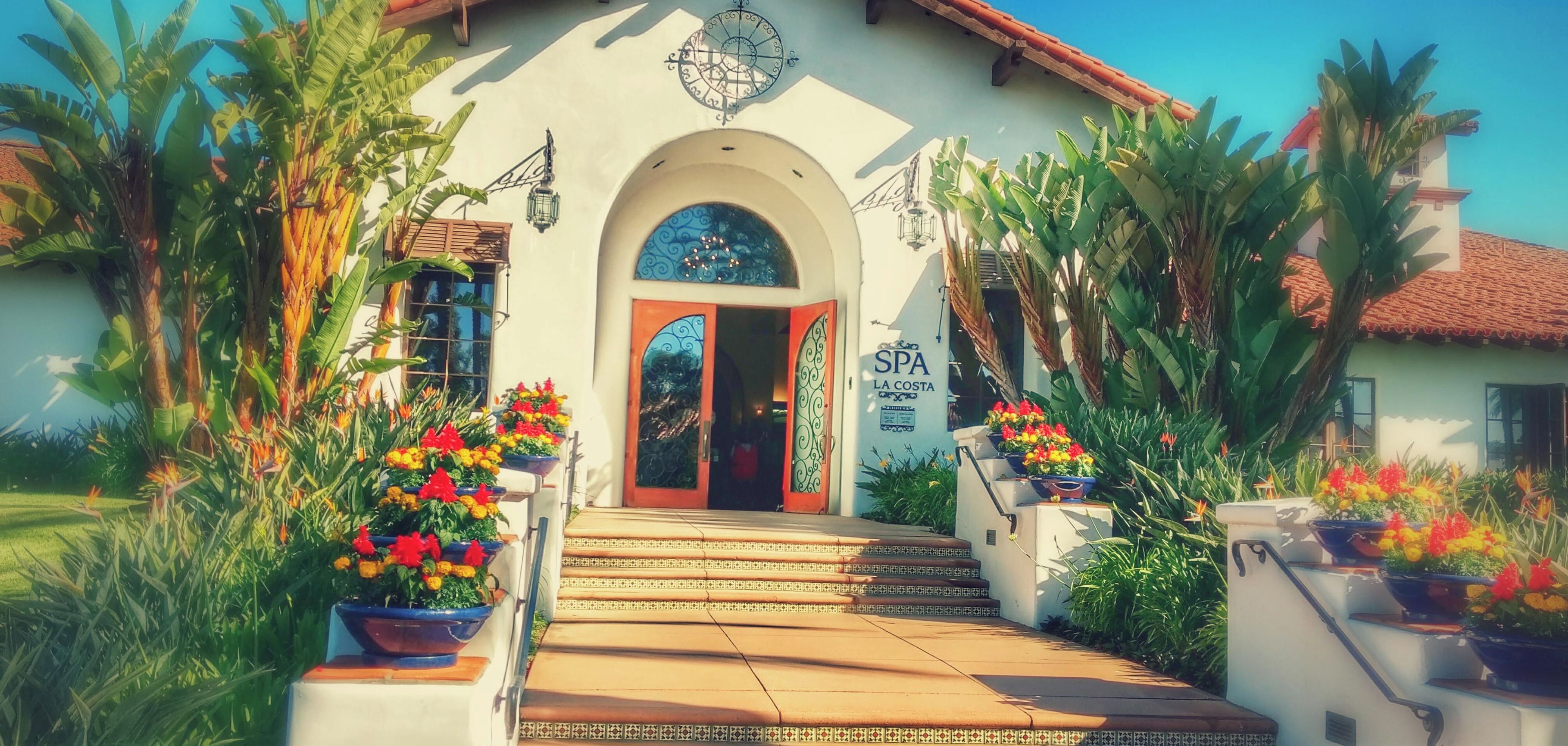 Un bâtiment avec un toit recouvert de tuiles, une entrée centrale dotée d’une porte en verre et une enseigne indiquant « SPA LA COSTA ».