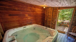 A wooden cabin with a hot tub, wooden deck, and a picnic table. - Mountaineer Cabin 6 - Hot Tub & Gas Fireplace close to New River Gorge (Hico)