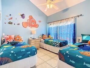 A bedroom with two beds, a ceiling fan, a nightstand, a lamp, and a window with curtains. - 10 minutes to Disney! Two Pools & Spa! No Carpet! Themed Rooms @The Nemo House (Kissimmee)