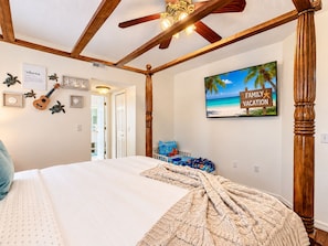 A bedroom with a bed, a ceiling fan, a wall-mounted TV, and a framed picture of a beach. - 10 minutes to Disney! Two Pools & Spa! No Carpet! Themed Rooms @The Nemo House (Kissimmee)