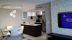 A modern kitchen with a central island, white cabinets, and stainless steel appliances. - Marbella del Caribe Condo - Amazing Oceanfront View (Carolina)
