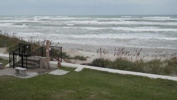 Blick auf die Küste mit einer Treppe, die zum Strand führt.