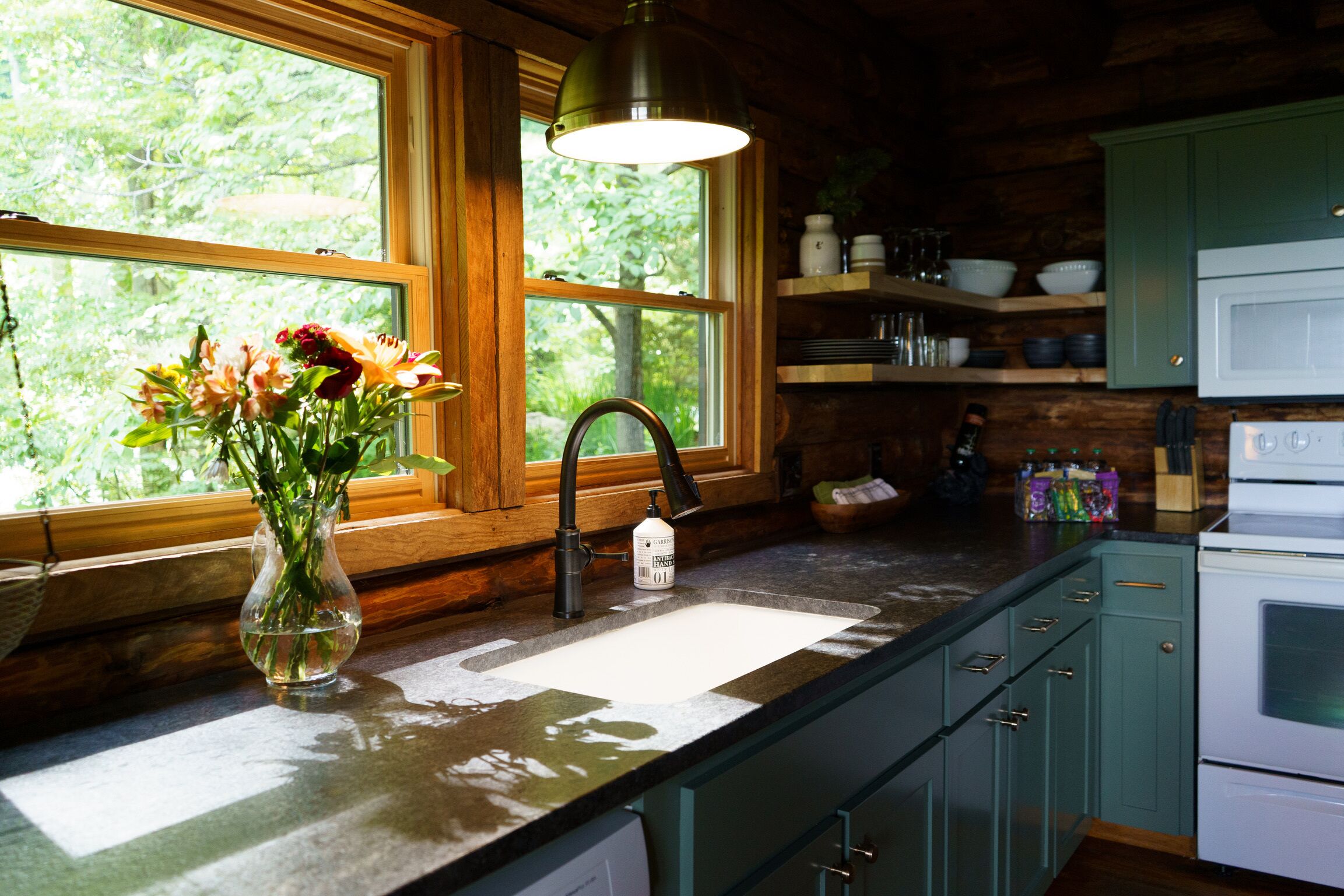 A kitchen with a window, a sink, and wooden cabinets.