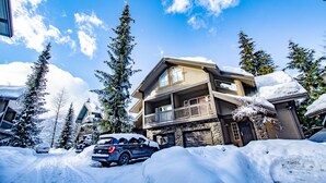 A multi-story house with a stone facade, a balcony, and a garage. - Snowy Creek 4 - Ski in Ski out, Private Hot Tub, Short Walk to Whistler Village (Whistler)