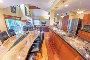 Una cocina amplia con una isla grande, armarios de madera y electrodomésticos de acero inoxidable.
