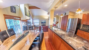 A spacious kitchen with a large island, wooden cabinets, and stainless steel appliances. - Snowy Creek 4 - Ski in Ski out, Private Hot Tub, Short Walk to Whistler Village (Whistler)