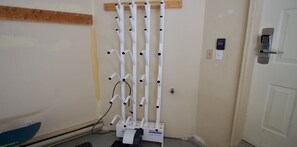 Una habitación con una puerta blanca, un dispositivo de seguridad montado en la pared y una estructura en forma de escalera blanca.