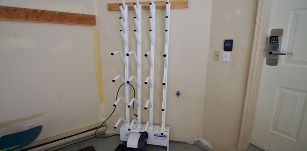 A room with a white door, a wall-mounted security device, and a white ladder-like structure.