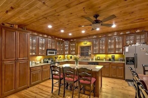 A kitchen with wooden cabinets, a microwave, a stove, and a refrigerator.
