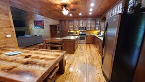 Un interior de madera con una zona de cocina equipada con refrigerador, microondas, horno y alacenas.