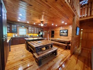 A wooden interior with a kitchen, dining area, and a staircase.