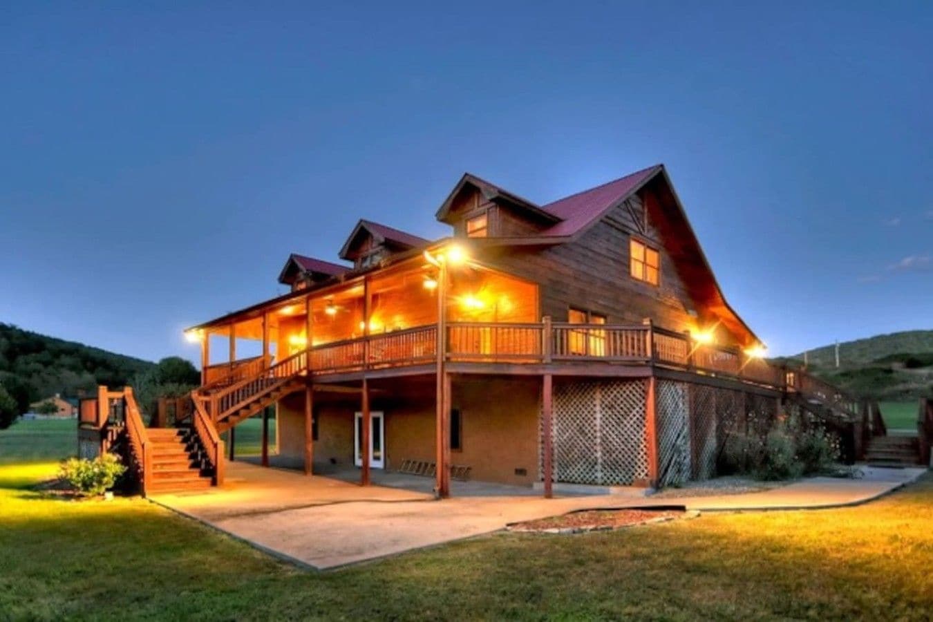 A large wooden building with multiple levels, a balcony, and a staircase leading to the upper floor.