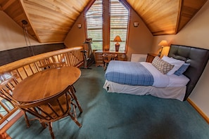Relax in this inviting room with a comfortable bed, dining area, and space for work or reading.