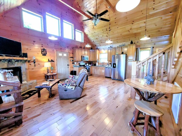 A spacious cabin interior with a living area, kitchen, and dining space. - Newly Built Cabin w/ Beautiful Views! Large Deck, LED Hot Tub, WiFi, King Suite (Gatlinburg)