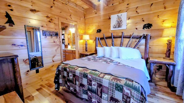 A wooden cabin room with a bed, a mirror, a dresser, and a lamp.