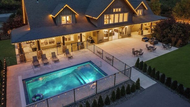 A house with a swimming pool, outdoor seating, and a well-lit patio area. - The Leavenworth Lodge - Swimming Pool, Pickleball (Leavenworth)
