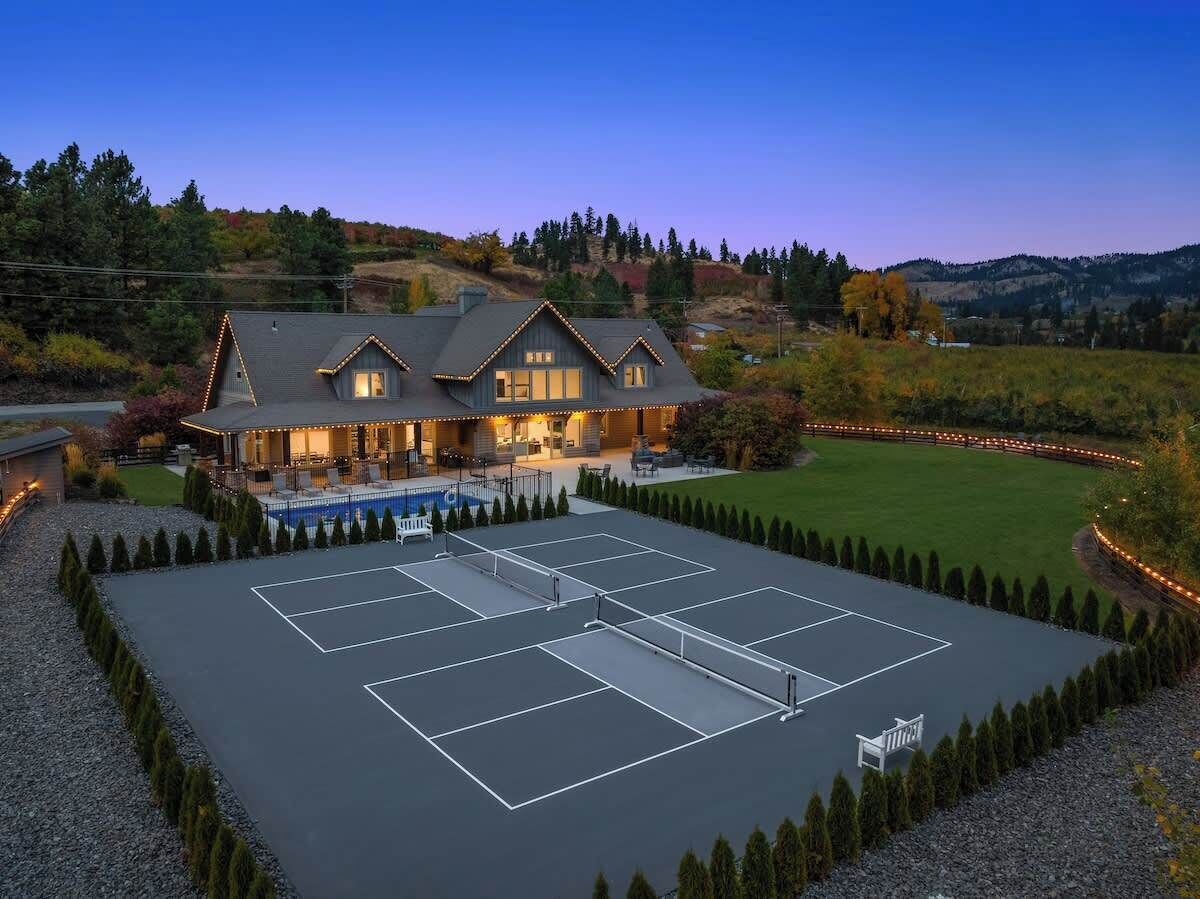 A large house with a tennis court and a pool.