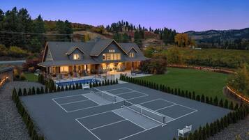 A large house with a tennis court and a pool.