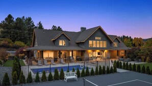 A large house with a swimming pool, tennis court, and a well-lit outdoor area. - The Leavenworth Lodge - Swimming Pool, Pickleball (Leavenworth)