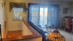 Ein Wohnzimmer mit Treppe, Sofa, Couchtisch und einem Hund.