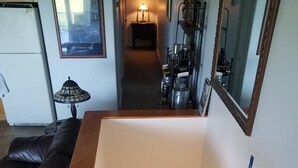 Eine Treppe mit Holzstufen und Geländer, die zu einer Zwischenebene mit einer Lampe führt.