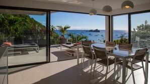 A modern outdoor dining area with a view of the sea and boats. - NEW Villa AKA walking distance to the beach (Saint Barthelemy)