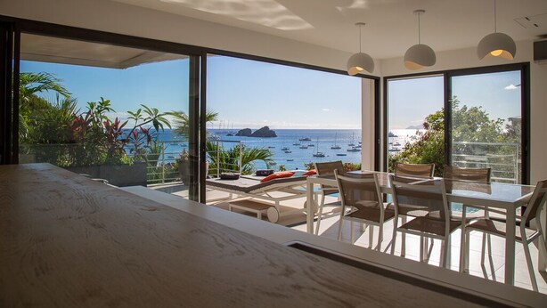 A modern dining area with a view of the sea and boats. - NEW Villa AKA walking distance to the beach (Saint Barthelemy)