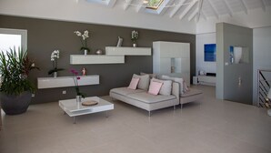 A modern living room with a sofa, coffee table, and potted plants. - NEW Villa AKA walking distance to the beach (Saint Barthelemy)