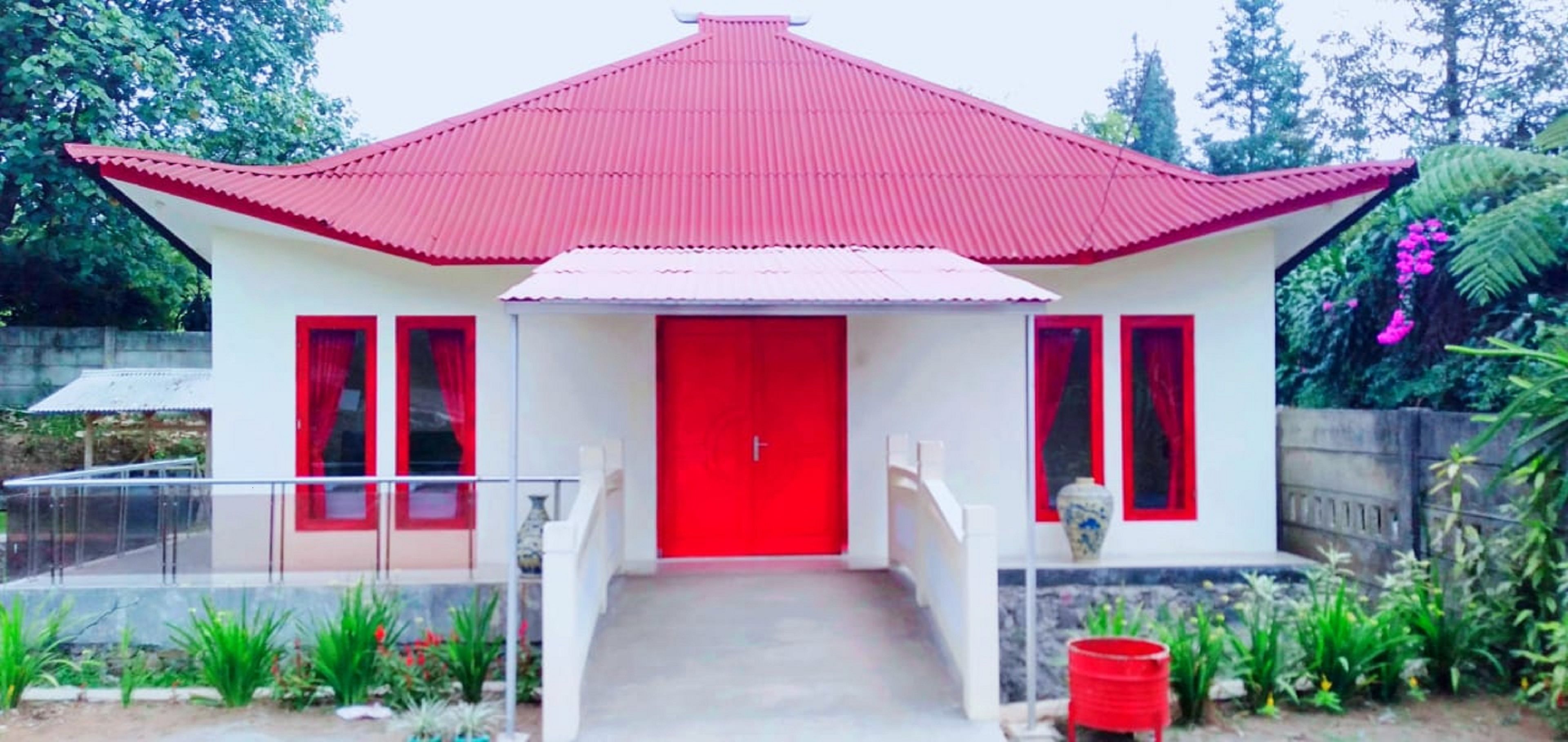 A two-story building with a red roof and white walls.