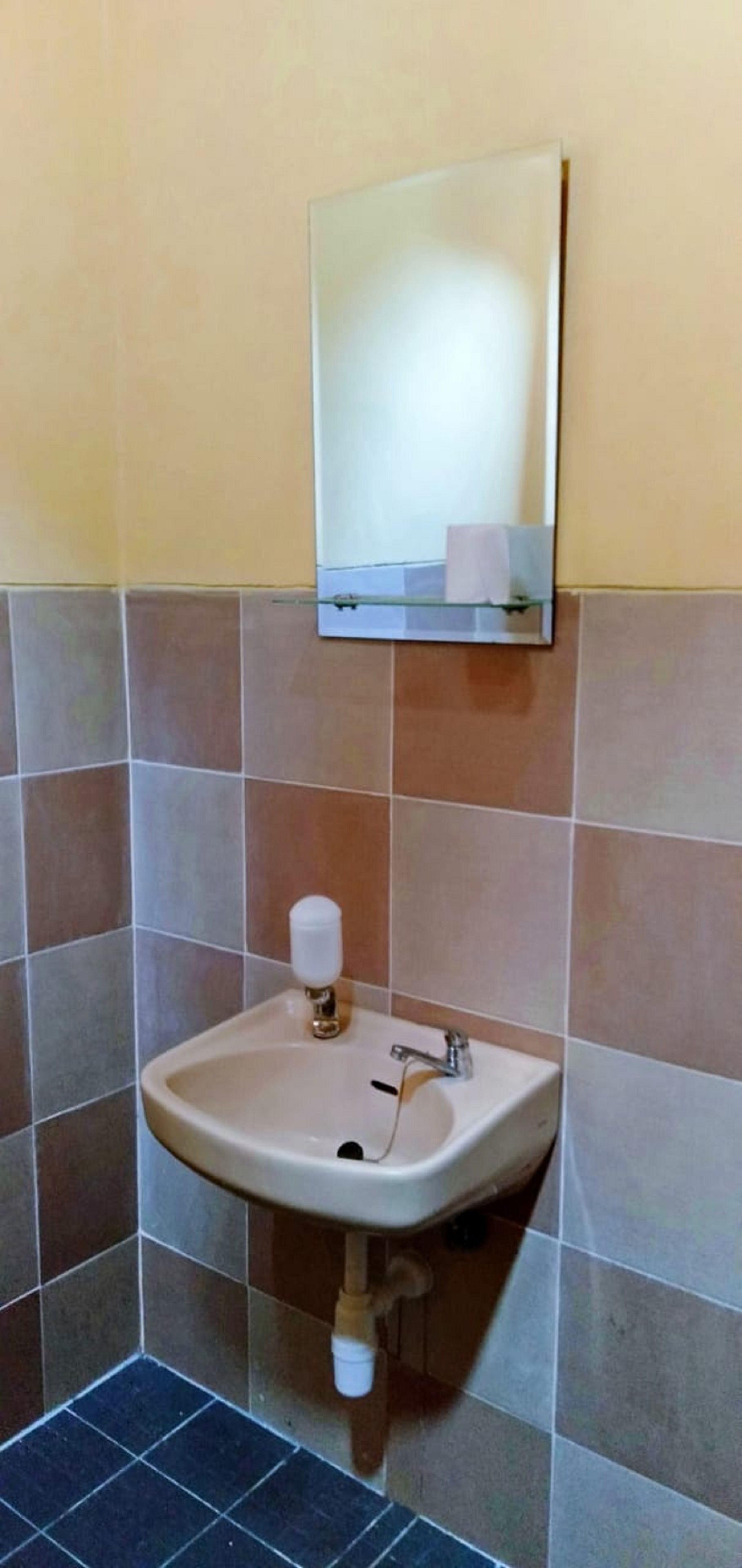 Baño con lavabo, espejo y perchero.