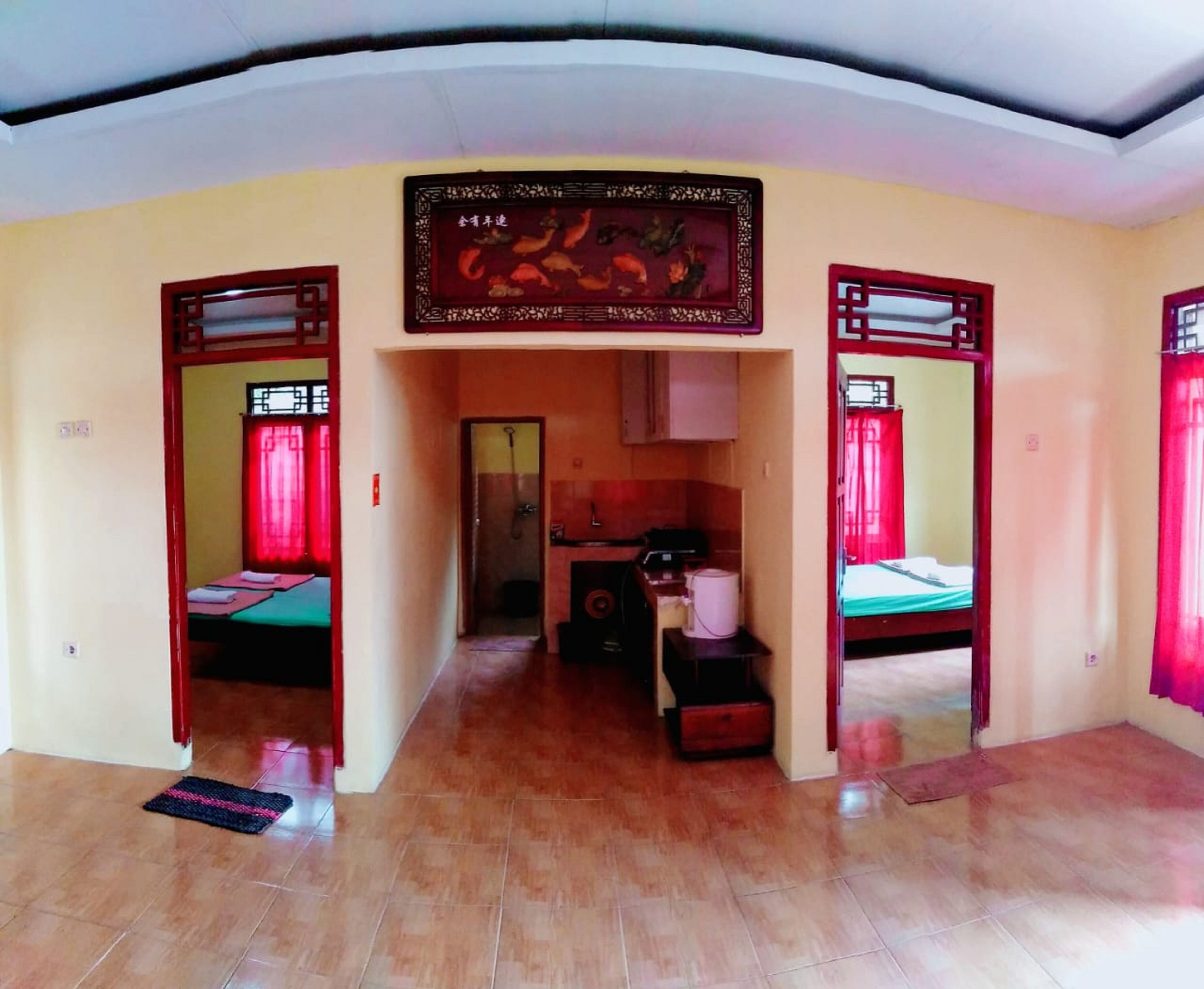 A hotel room with a tiled floor, a bed, a desk with a chair, and a small kitchenette.