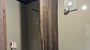 A bathroom with a wooden partition, a toilet, and a shower area. - N'jung Bali Camp (Kintamani)