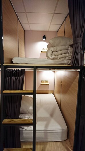 A bunk bed room with a headboard, a bedside table with a lamp, and curtains. - Temple Side - Hostel (Tainan)