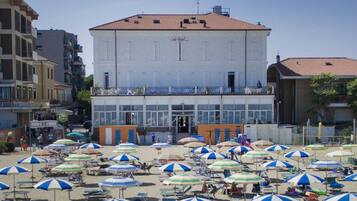 Am Strand, weißer Sandstrand, Sonnenschirme, Strandtücher