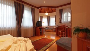 A hotel room with a bed, a desk, a chair, a television, and a plant. - Hotel Restaurant Adler (Lahr)