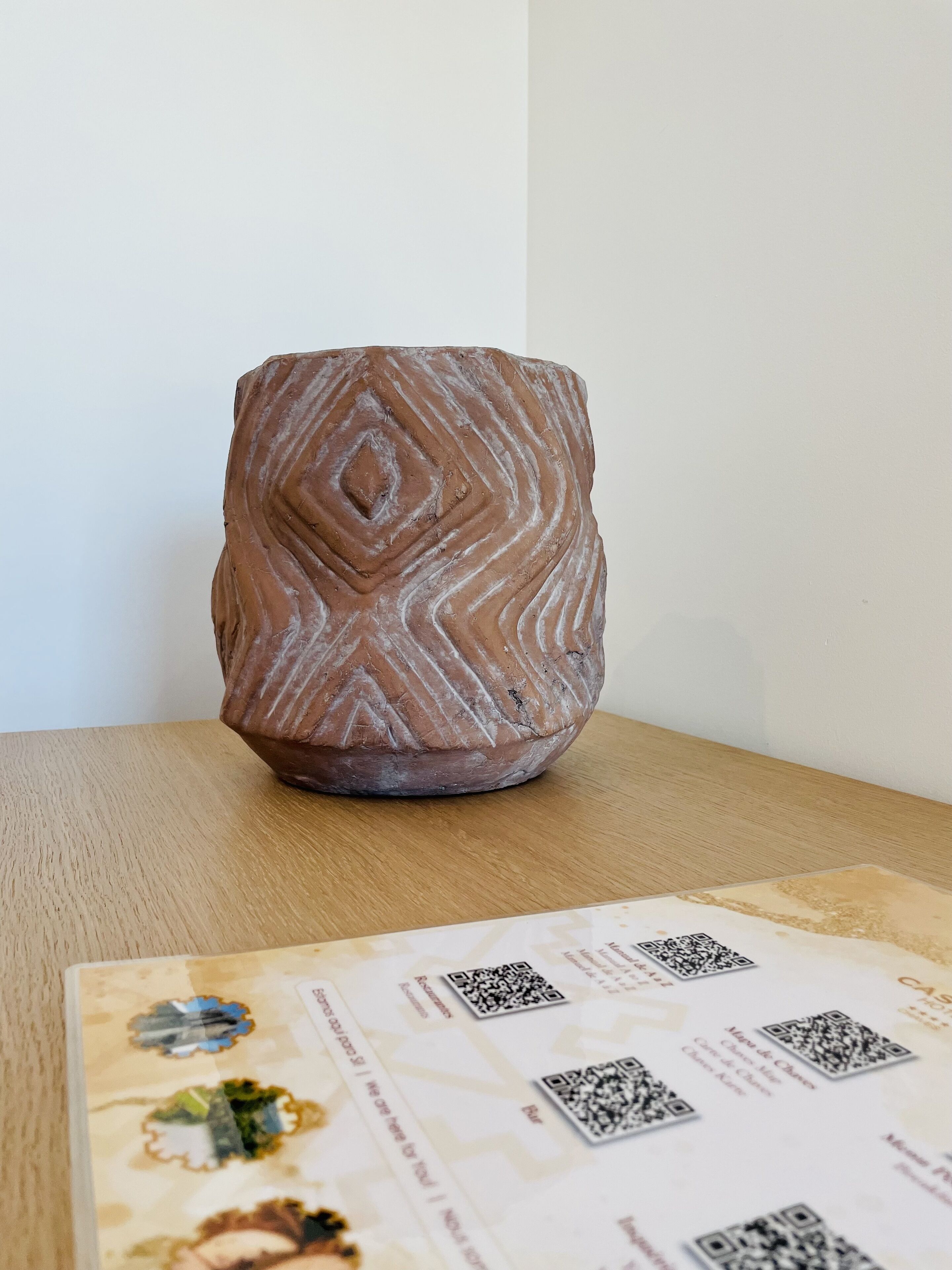 A ceramic mug with a geometric pattern on a wooden surface.