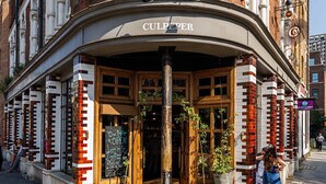 A corner building with a sign reading "CULPEPER" and a "OPEN" sign outside. - The Culpeper (London)