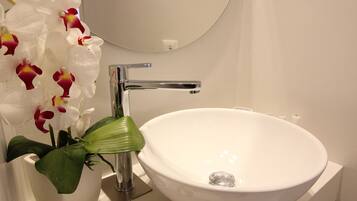 A bathroom with a white sink, a mirror, a towel, and a starfish decoration.