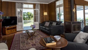 A living room with a television, sofa, fireplace, and a view of the outdoors. - Rosewood Estate (Beechmont)