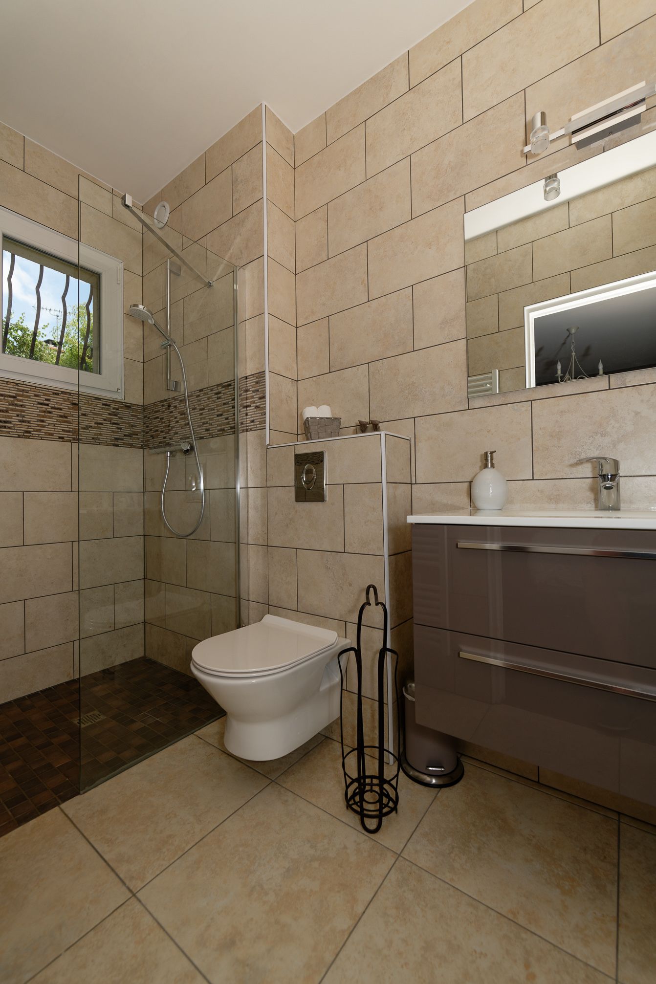 A modern bathroom with a shower, toilet, and vanity.