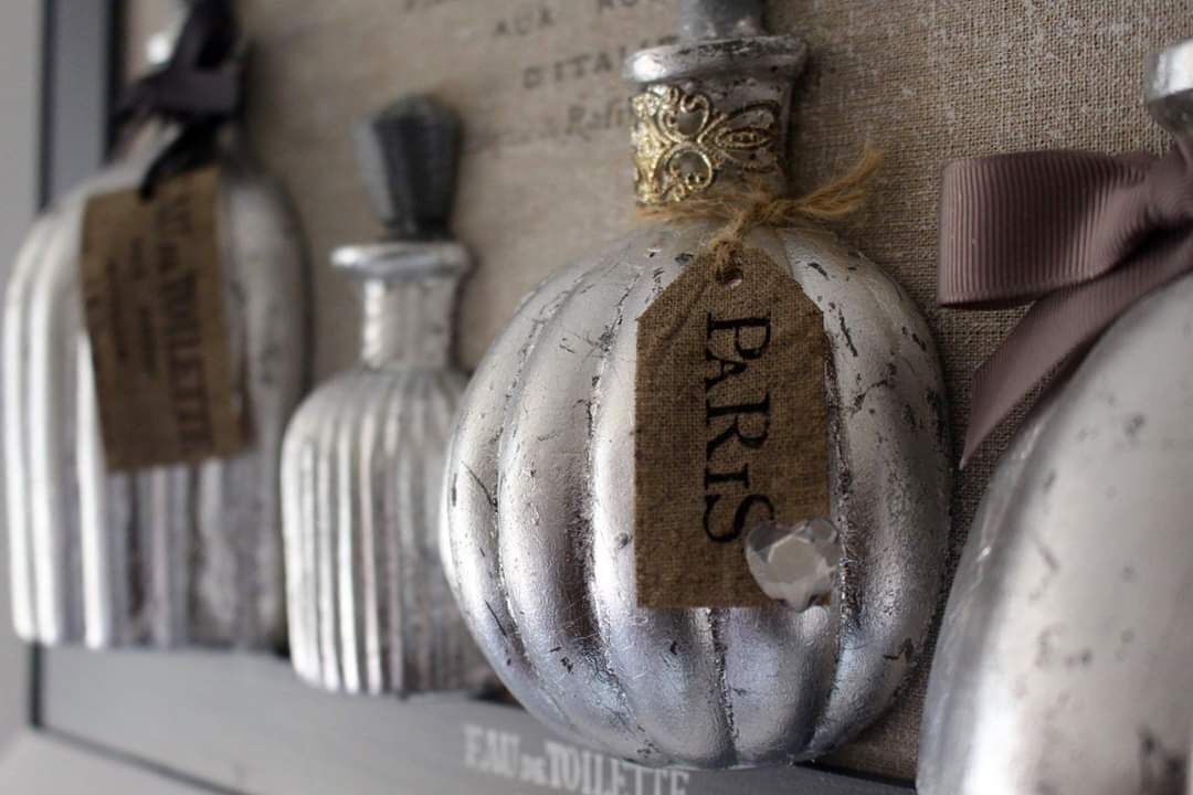A row of vintage-style perfume bottles with labels, each tied with a ribbon.