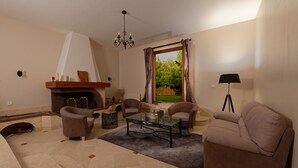 A living room with a fireplace, two sofas, a coffee table, and a floor lamp. - Le Clos Magedon (Médan)
