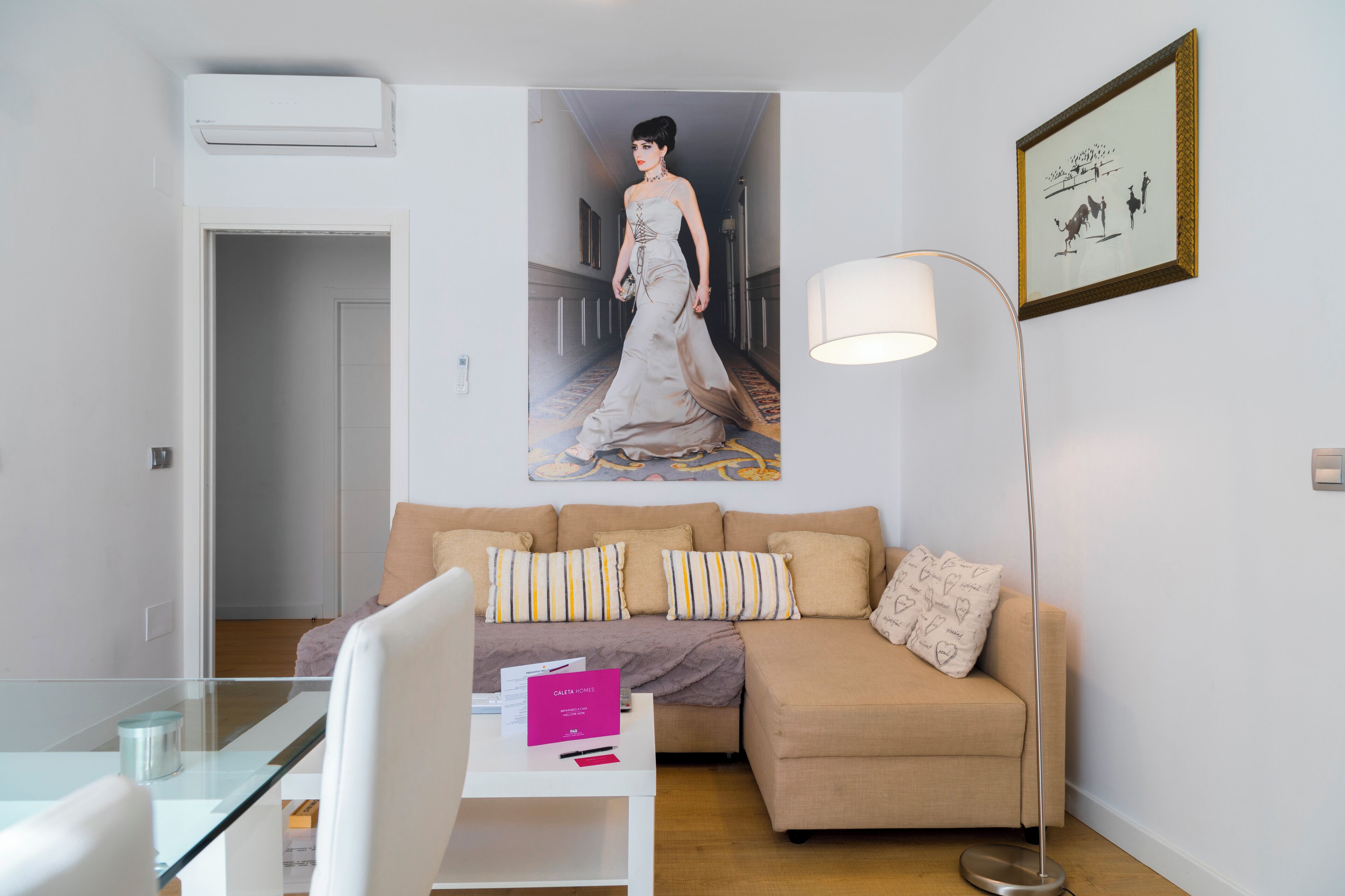 A modern living room with a beige sofa, a glass coffee table, and a floor lamp.