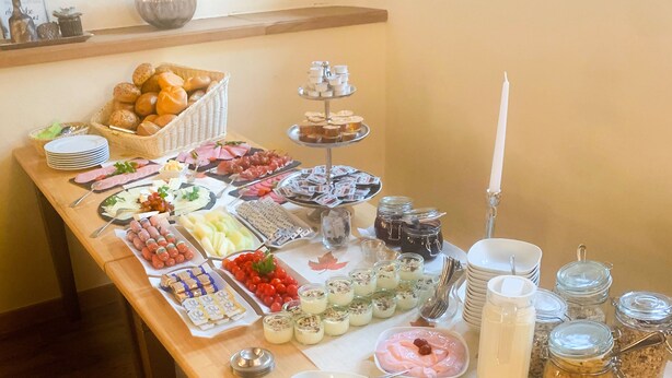 A buffet table with various food items and condiments. - Landhaus Hui Wäller (Greifenstein)