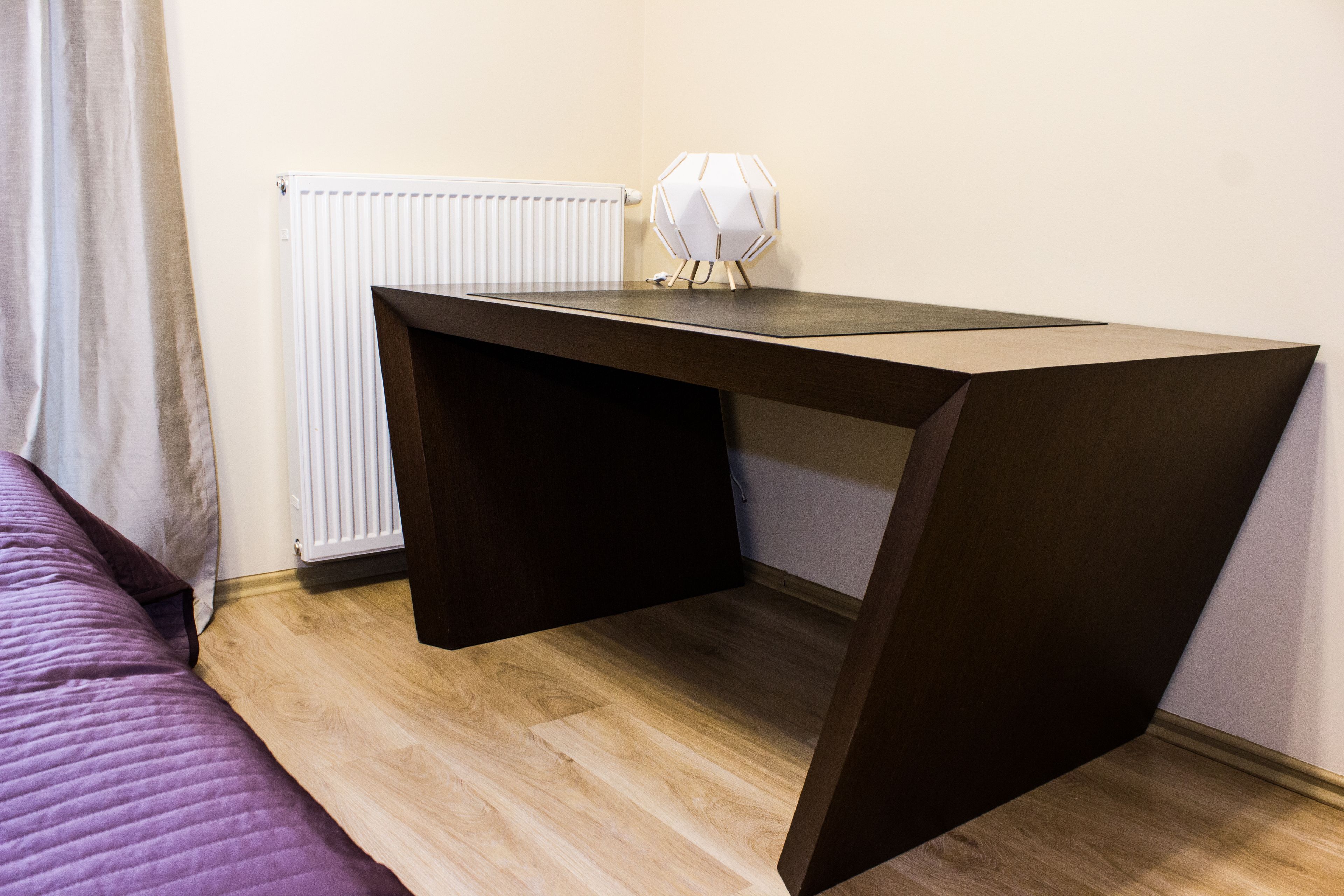 Une chambre avec un lit, un bureau et un radiateur.