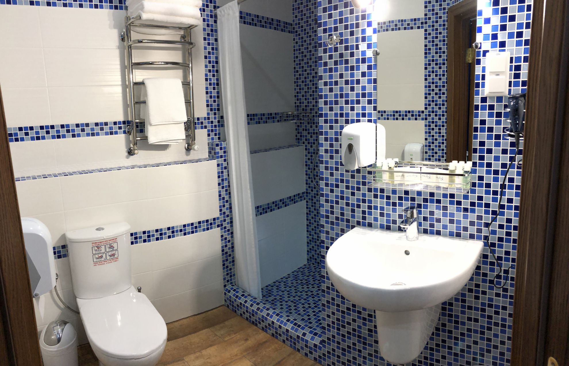 A bathroom with a toilet, sink, and towel rack.