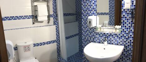 A bathroom with a toilet, sink, and towel rack.