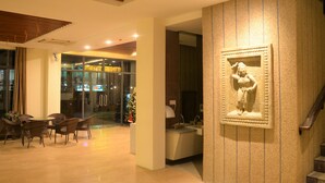 A lobby with a reception desk, a staircase, and a Christmas tree. - Thazin Palace A Hotel (Ngapali)