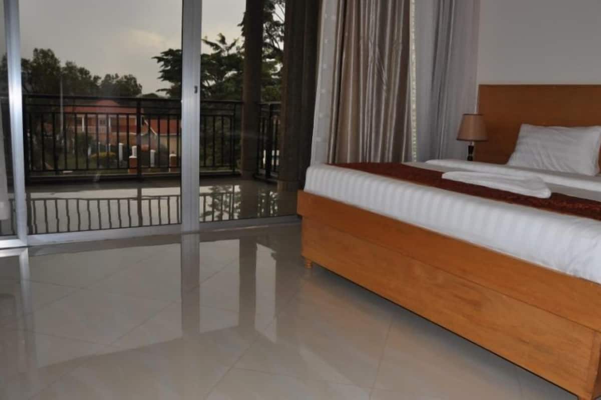 A hotel room with a large bed, a balcony with a view, and a modern design.